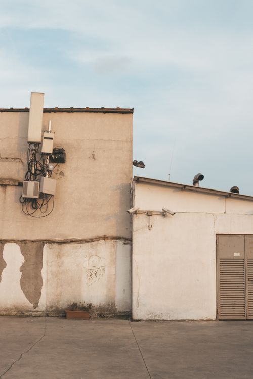 Free Urban building with industrial equipment and worn exterior walls in daylight. Stock Photo