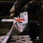 Blacksmith shaping hot steel on an anvil, photo by Sladjan Djordjevic on Pexels