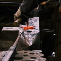 Blacksmith working hot metal on an anvil, by Sladjan Djordjevic on Pexels