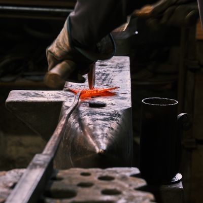 Tongs and hammer over a swage block — photo by Sladjan Djordjevic on Pexels