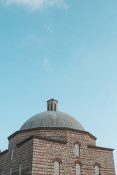 这座历史悠久的建筑拥有圆顶和砖砌立面，在晴朗的蓝天下显得格外醒目，非常适合建筑和旅游主题