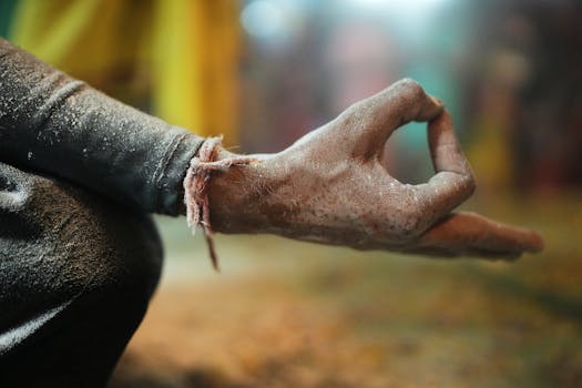 A close-up of a dusty hand in a mudra gesture, signifying calm and meditation.