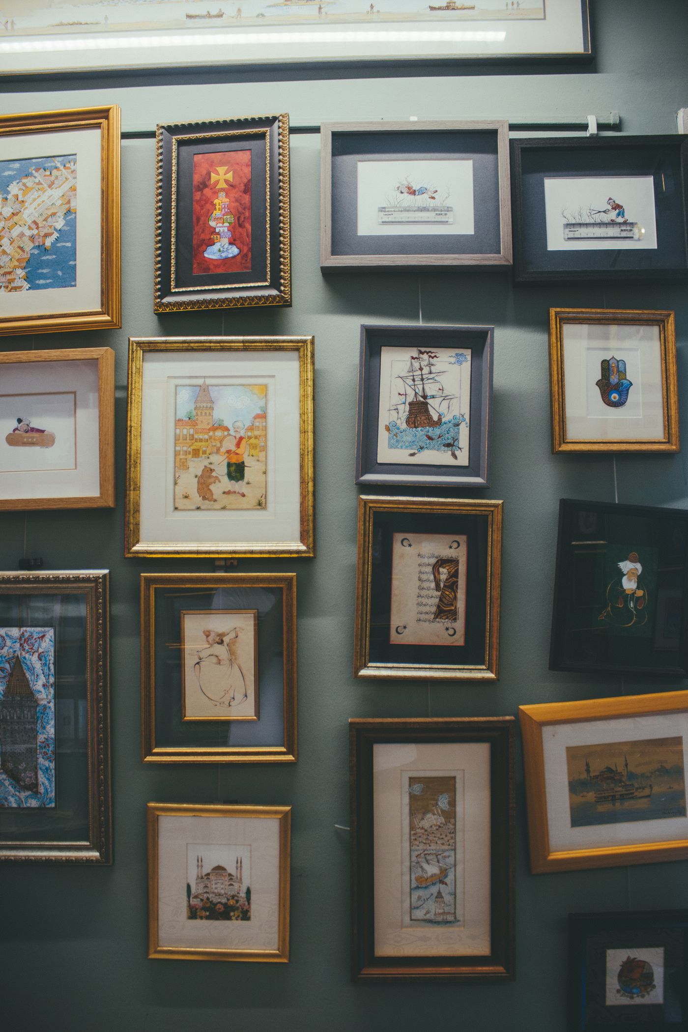 A wall hung with a group of framed pictures of different sizes.
