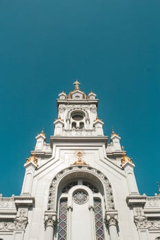 低角度镜头下，历史悠久的教堂立面映衬着清澈的蓝天，展现出错综复杂的建筑细节