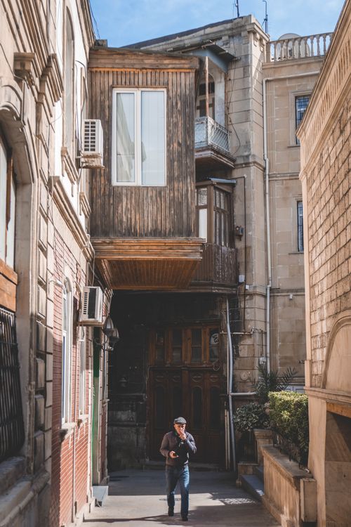 Free A person walks through a historic urban alleyway with unique architecture. Stock Photo