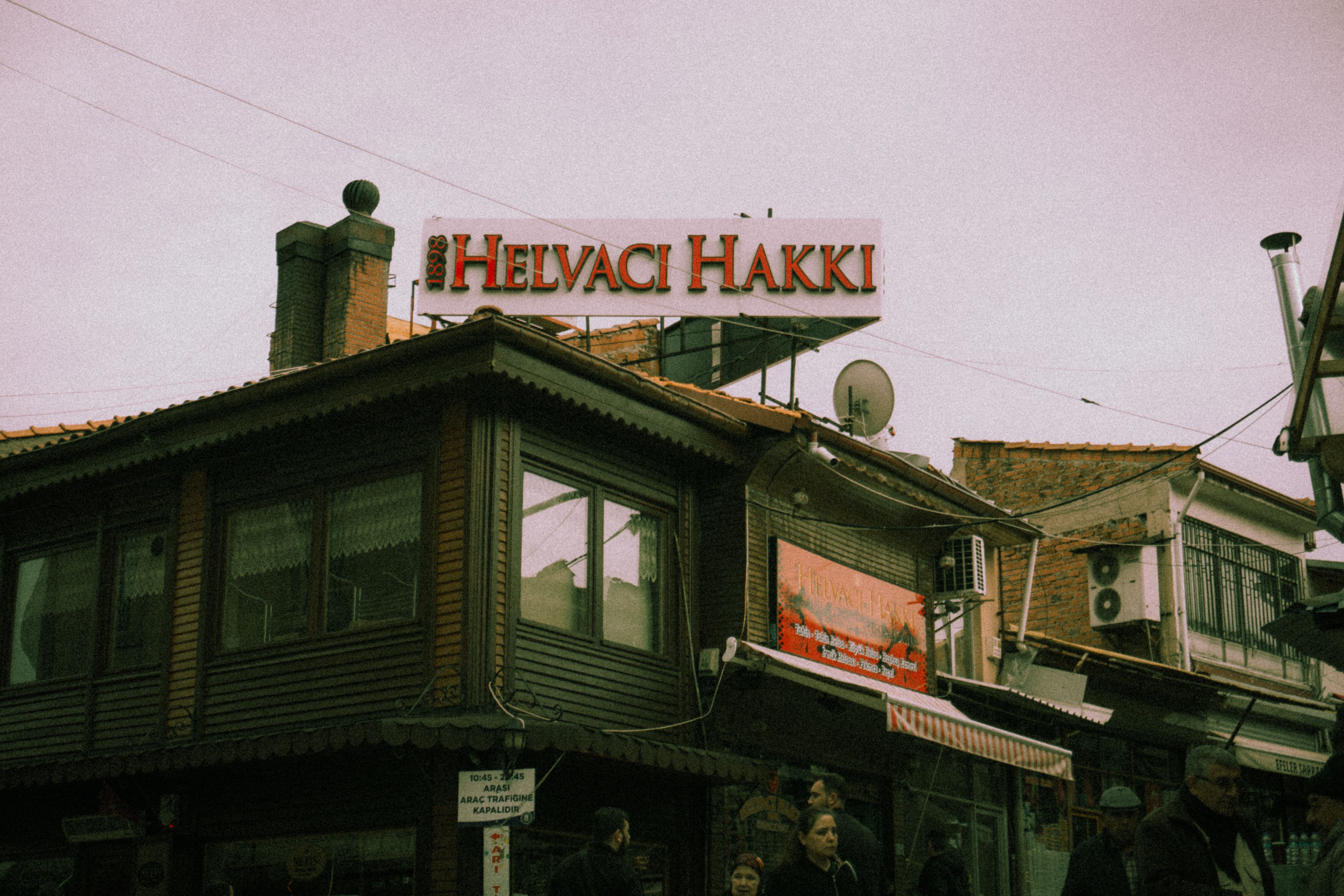 Vintage look at a Turkish street with traditional wooden architecture and local shop signs.