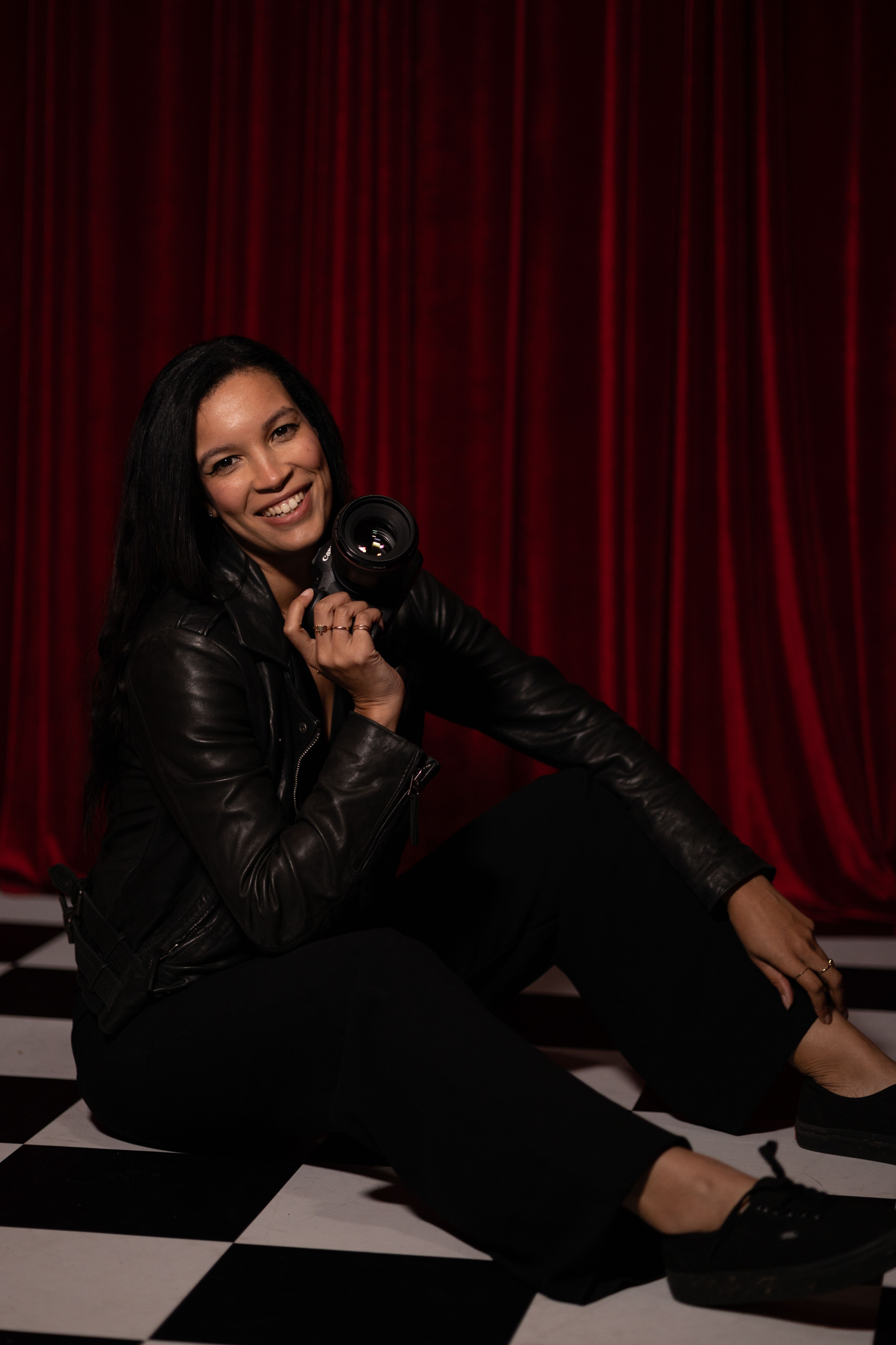 Sitting Woman in Black Leather Jacket Holding Camera · Free Stock Photo
