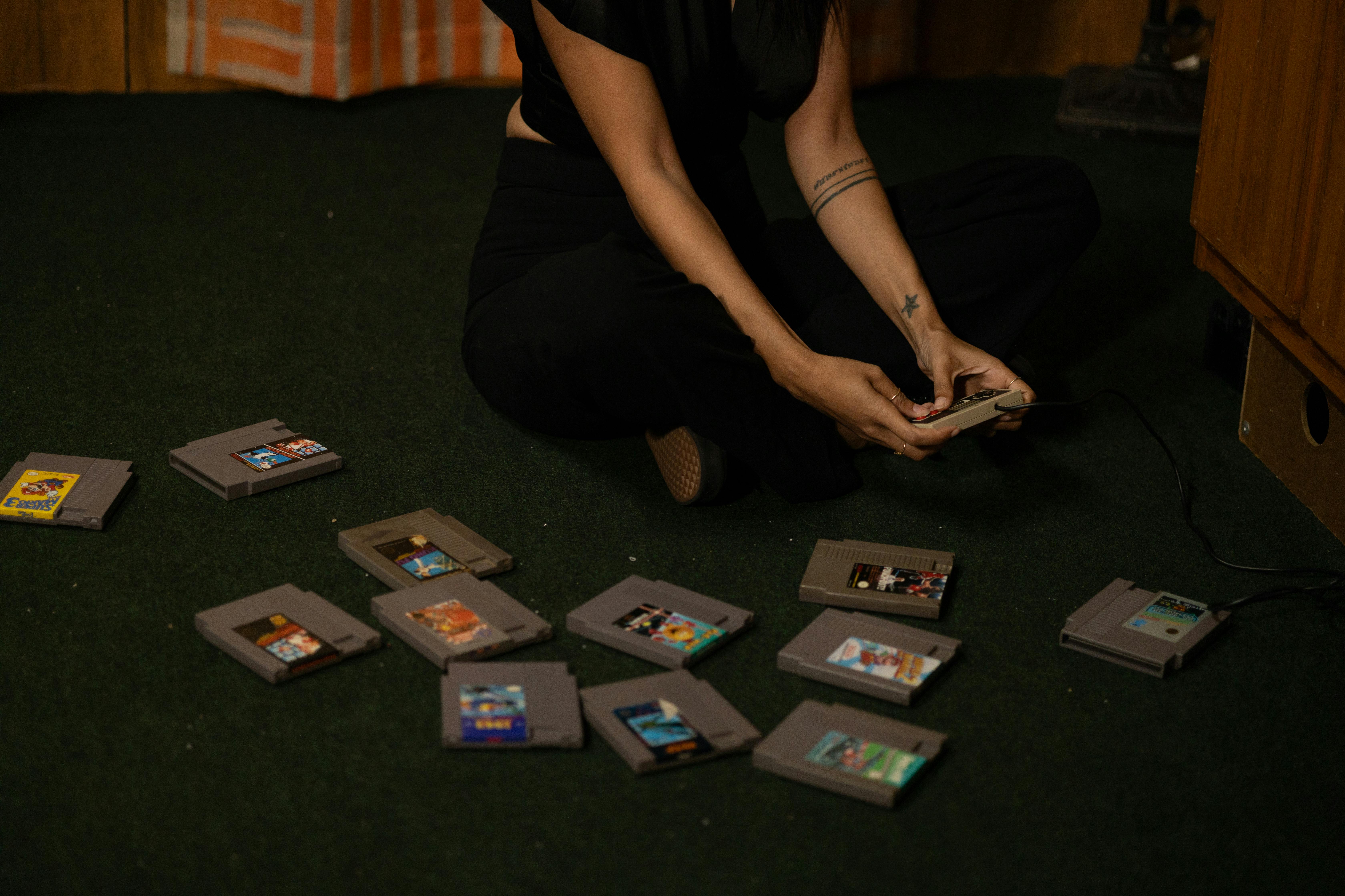 A woman sitting on the floor with a bunch of video games
