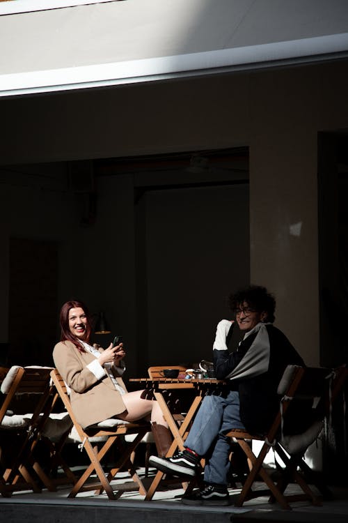 A woman and a man sitting at a table outside