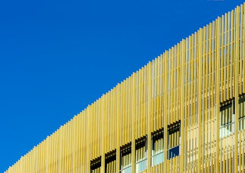 A building with a yellow metal facade against a blue sky