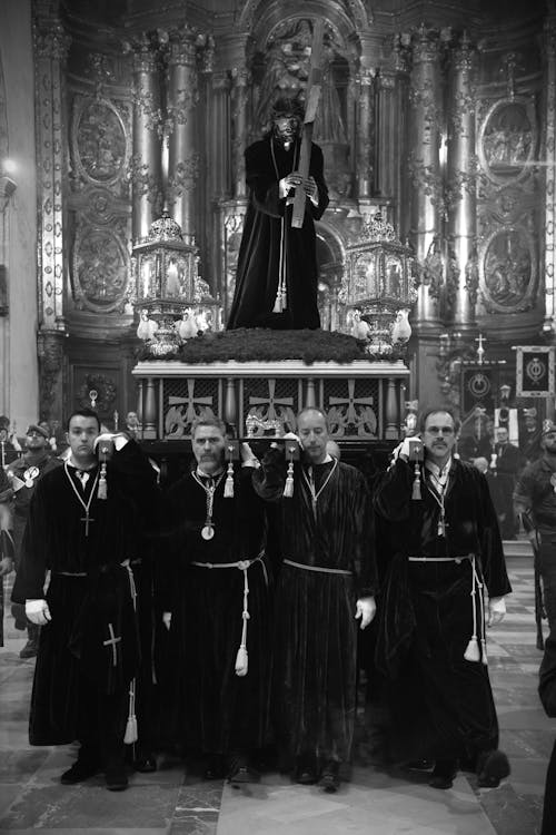 A group of priests standing in front of a statue