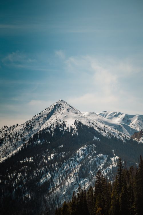 Free Breathtaking view of a snowcapped mountain peak with clear skies. Perfect for nature and travel themes. Stock Photo
