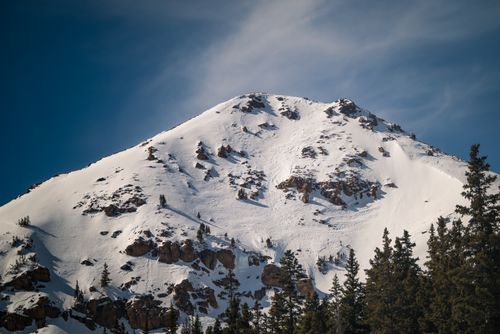 Free A pristine snow-covered mountain peak under a clear blue sky, highlighting nature's tranquility. Stock Photo