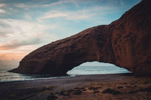 Free Rock formation arch on Legzira Beach, Morocco during sunset with scenic views. Stock Photo