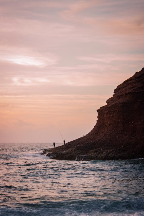 Fishermen under Barren Hill on Sea Shore