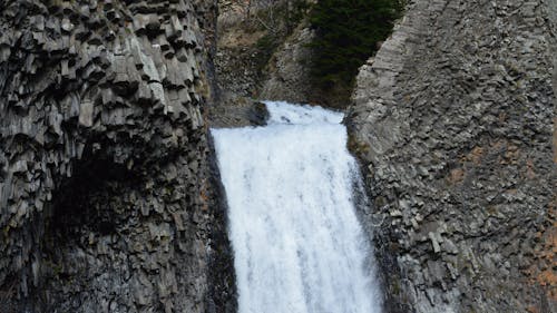 A waterfall is flowing down a rocky cliff