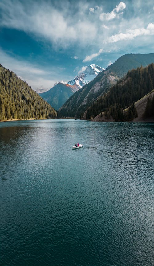 A boat is floating on a lake surrounded by mountains
