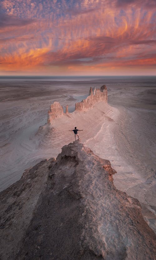 A person standing on top of a rock in the desert