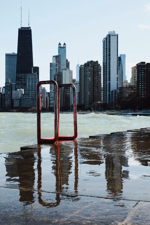 Free Stunning view of the Chicago skyline with reflections over a calm waterfront, showcasing urban architecture. Stock Photo