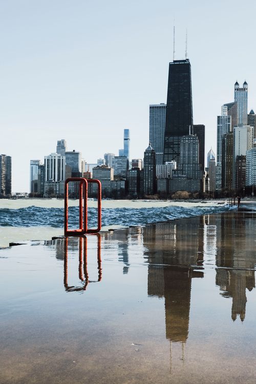 Free Scenic view of the iconic Chicago skyline reflecting in Lake Michigan's calm waters. Stock Photo