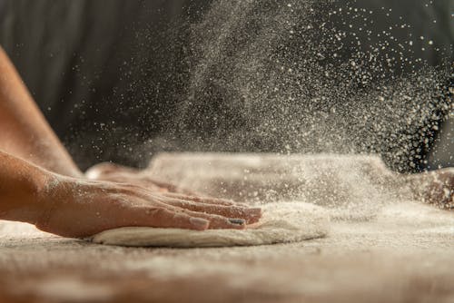 Woman Hand Preparing Dough with Flour