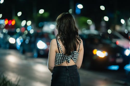 A woman standing in the middle of the street at night
