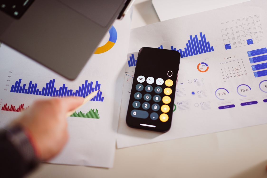 Dashboard financeiro impresso com calculadora digital para avaliação de preços e margem