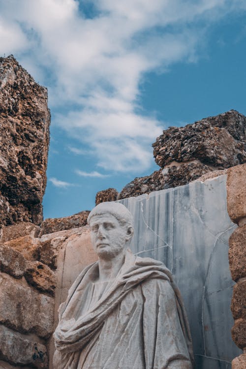 A statue of a man in front of a stone wall