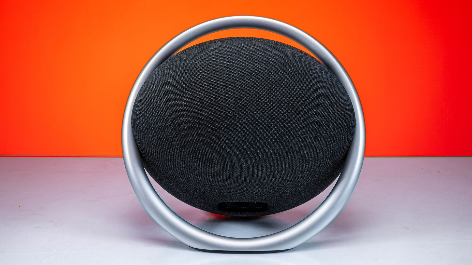 Sleek Bluetooth speaker showcased with a vibrant, bold orange background, emphasizing modern design and technology.
