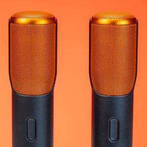 Two microphones against a warm orange background