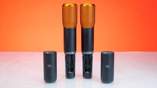 Three orange and black speakers sitting on top of a table
