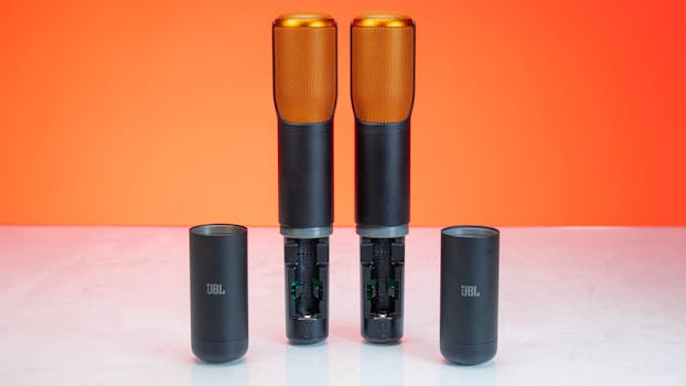 Pair of JBL microphones with orange grills on orange backdrop. Perfect for studio use.