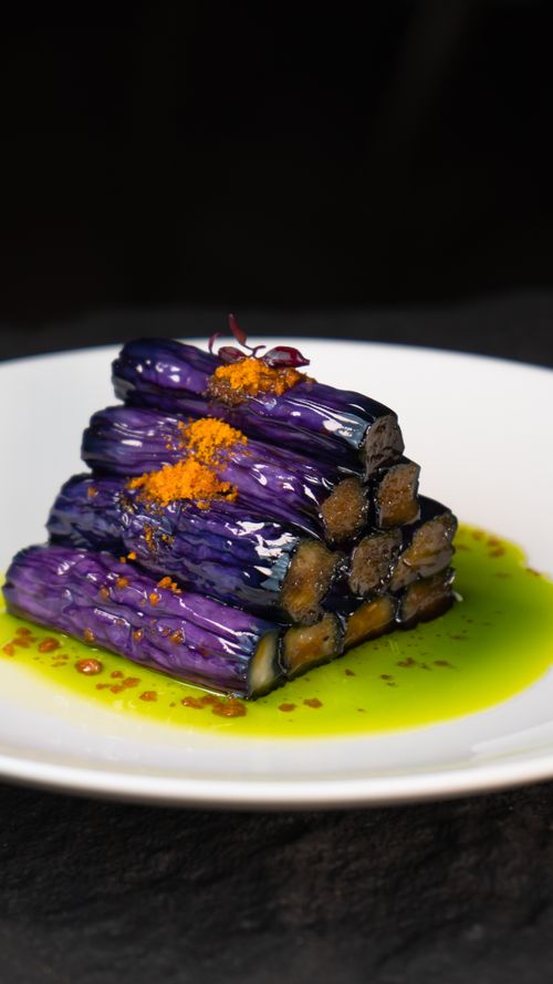 Free Tantalizing eggplant dish elegantly plated with colorful sauces, perfect for gourmet food lovers. Stock Photo