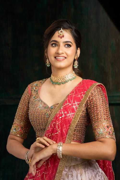A beautiful indian woman in a red and pink lehenga