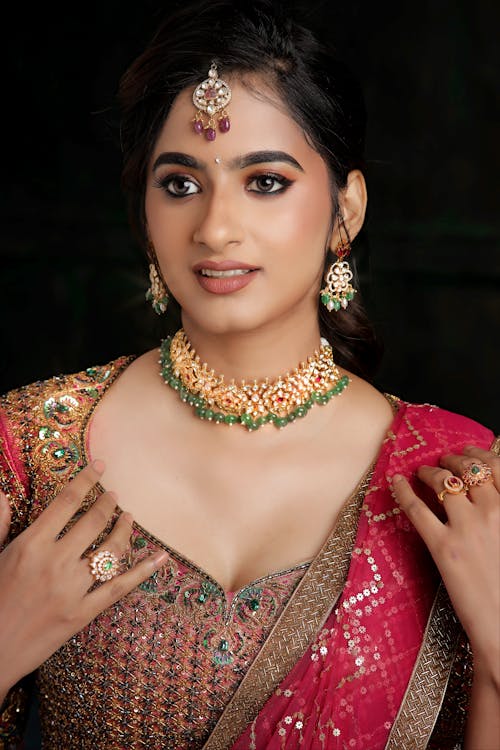 A beautiful indian woman in a pink sari and gold jewellery