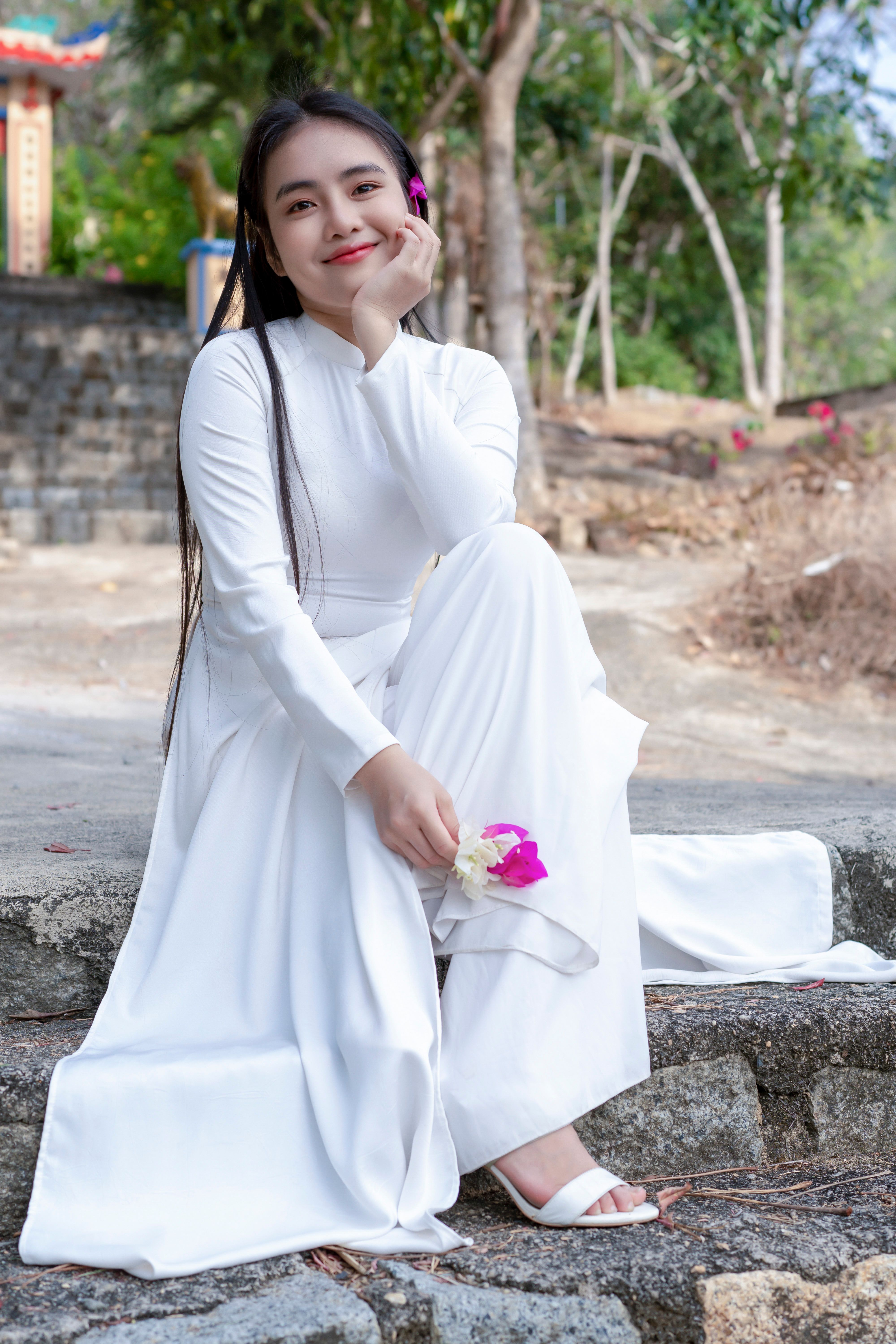 Smiling Woman in White Dress Sitting on Stairs · Free Stock Photo