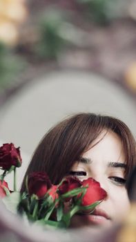 Artistic portrait of a woman with red roses in Istanbul. Captivating and elegant.
