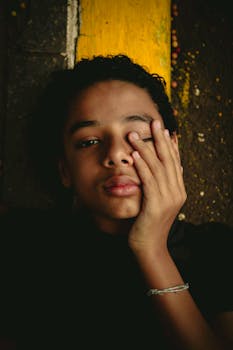 以圣保罗的城市背景为背景，一个小男孩触摸脸的特写肖像