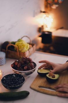 A cozy kitchen with fresh fruits and avocado preparation on a wooden cutting board in Berlin, Germany.