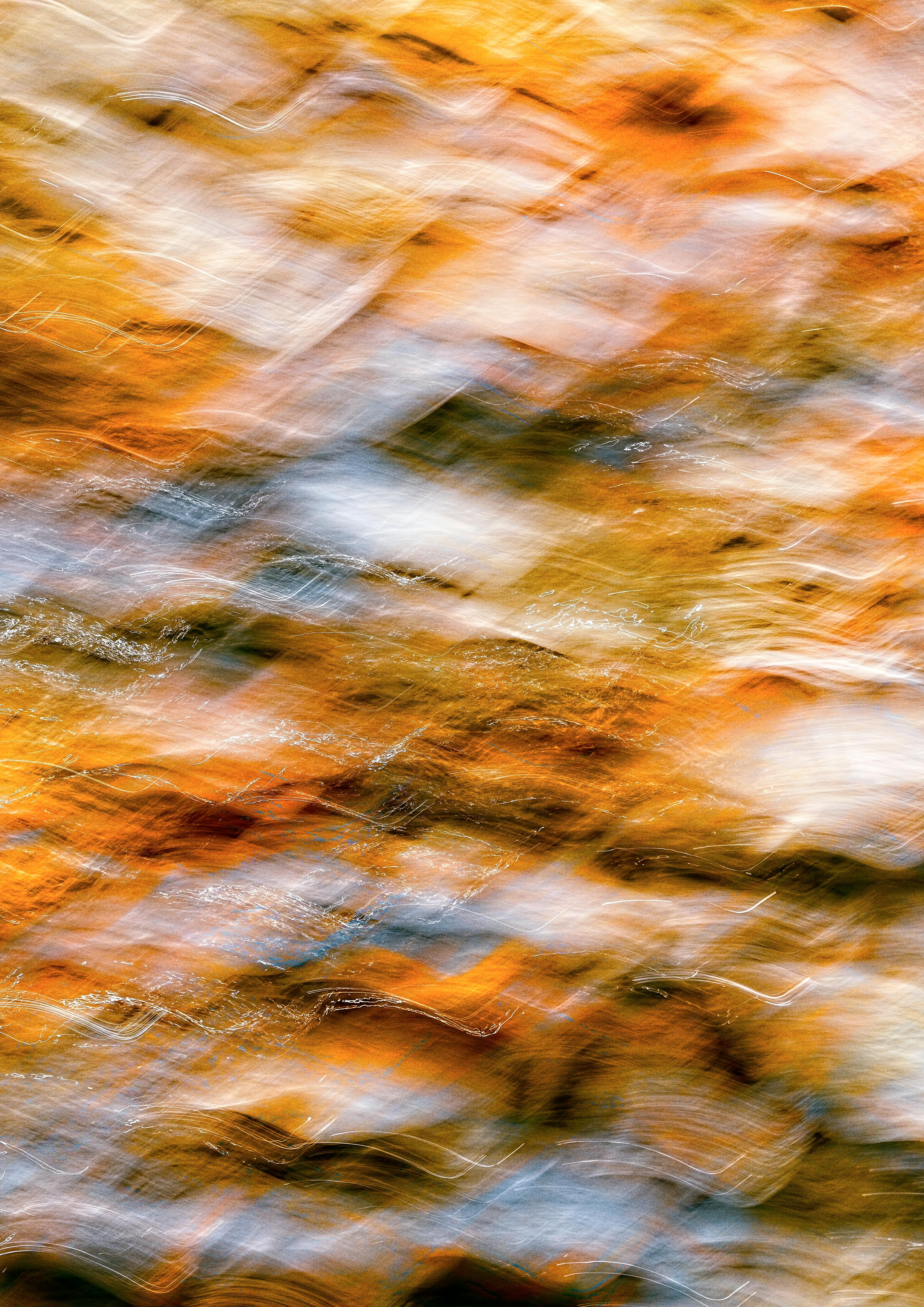 Dynamic abstract pattern with vibrant autumn hues captured in a motion blur effect.