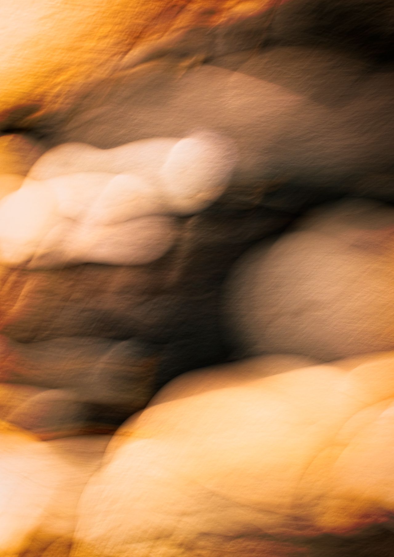 Ethereal abstract of smooth stones with warm, blurred textures creating a tranquil atmosphere