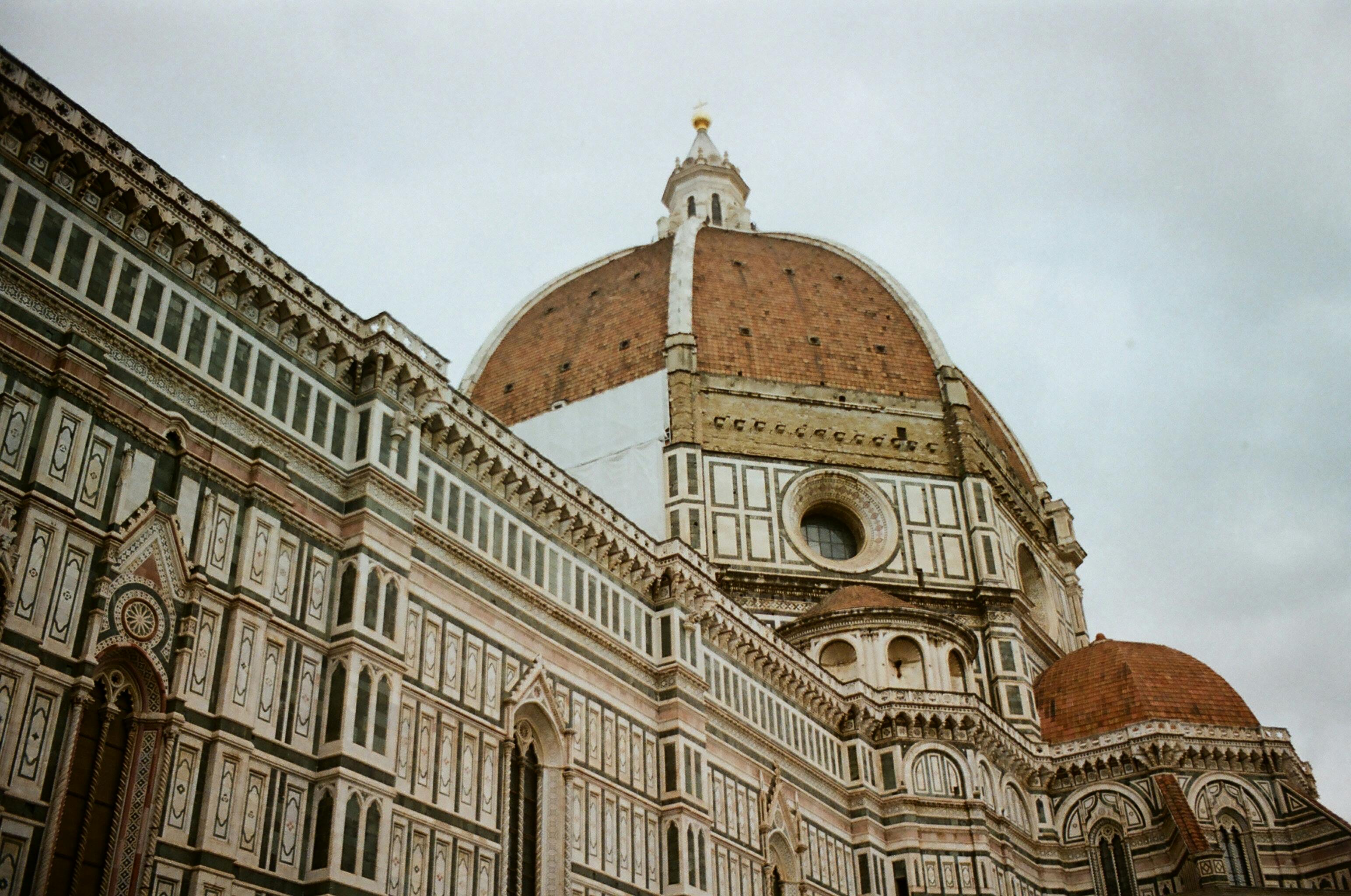 Low angle shot of the iconic Florence Cathedral dome highlighting its intricate Gothic architecture.