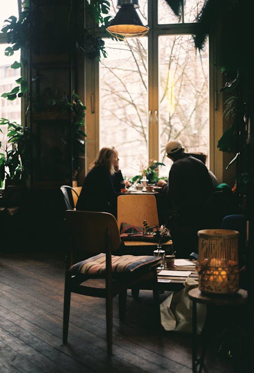 Two people sitting at a table in a cafe