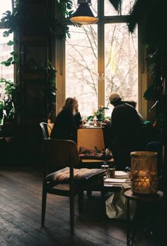 A warm, intimate café setting in Berlin, showcasing a couple enjoying a quiet moment by the window.