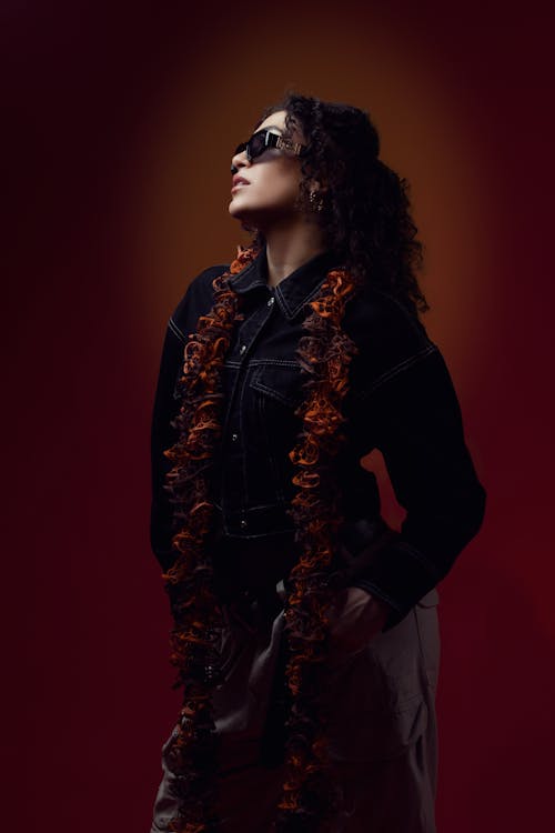 A woman in sunglasses and a scarf posing for a portrait