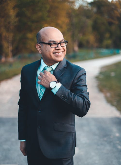 A man in a suit and tie adjusting his watch