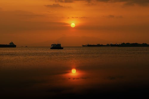 Foto profissional grátis de céu amarelo, costa, mar