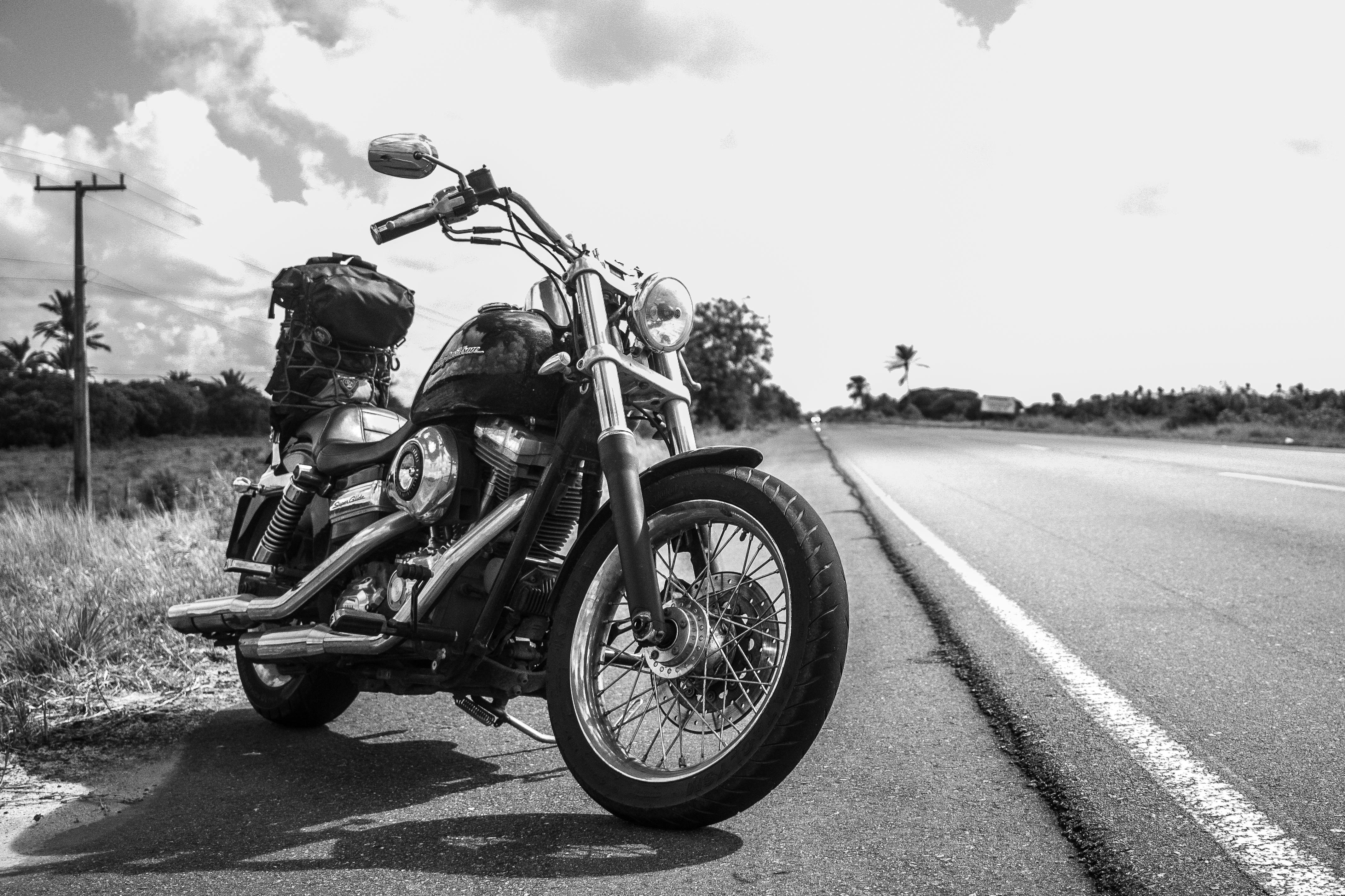Classic motorcycle on rural road, highlighting travel and adventure.