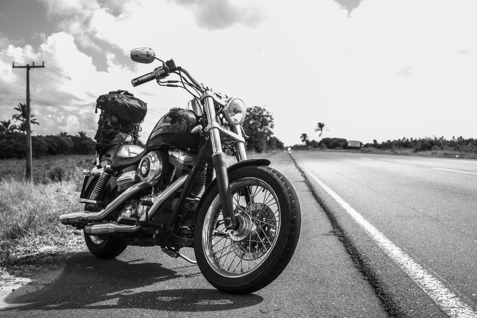 Classic motorcycle on rural road, highlighting travel and adventure.
