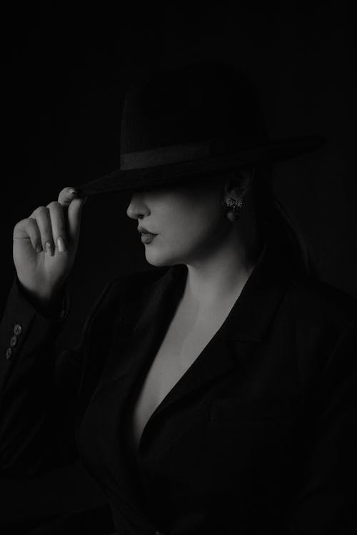 A woman in a black hat and suit